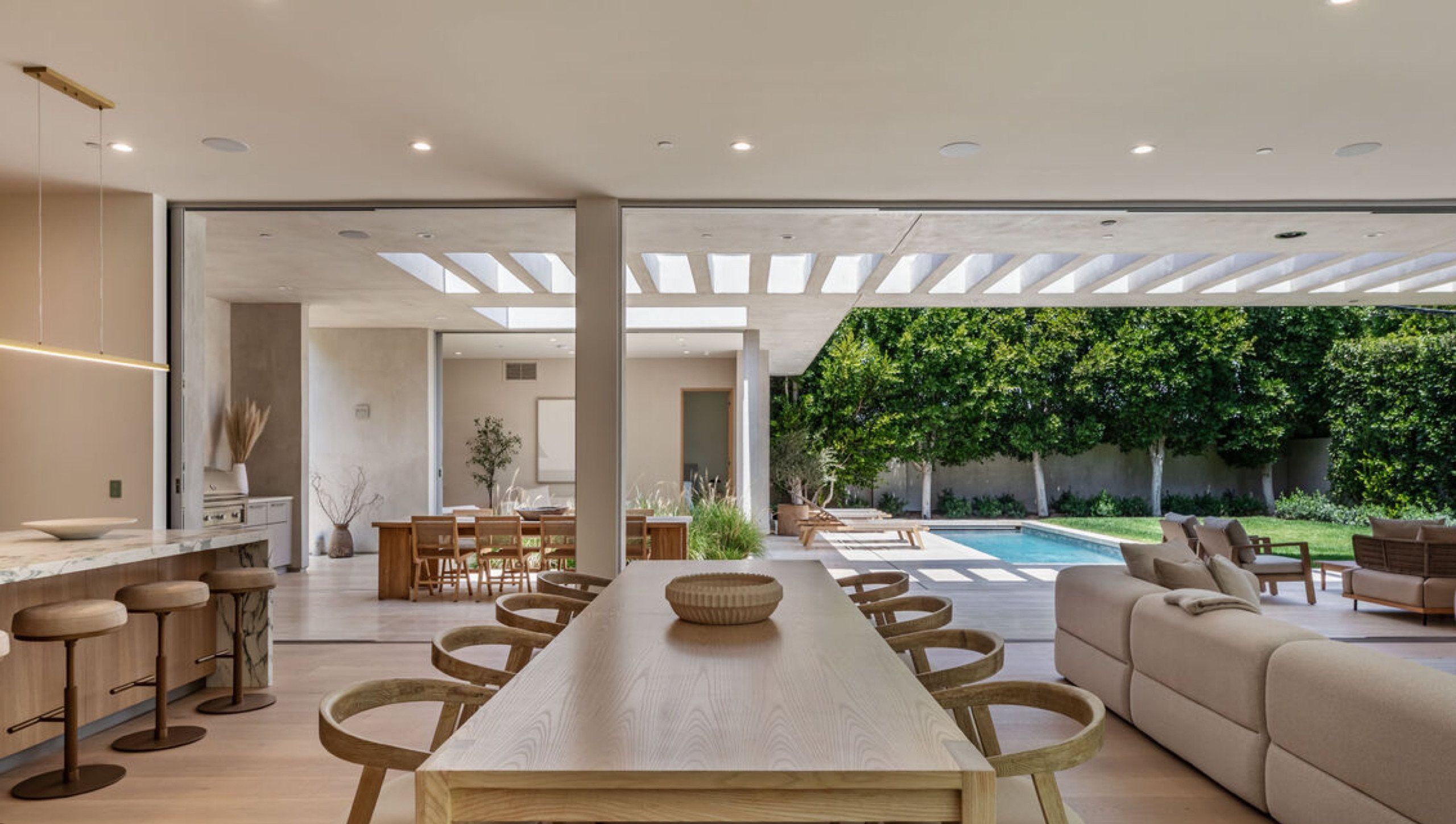 Dining table and kitchen island looking out to the pool
