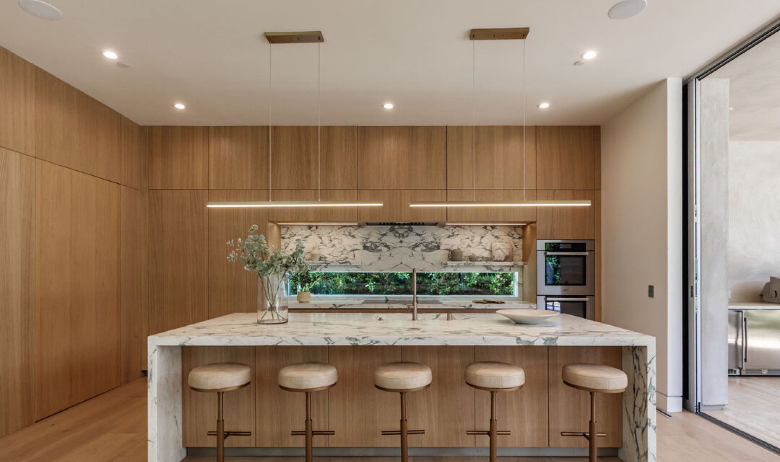 Kitchen with marble waterfall island and oak cabinetry