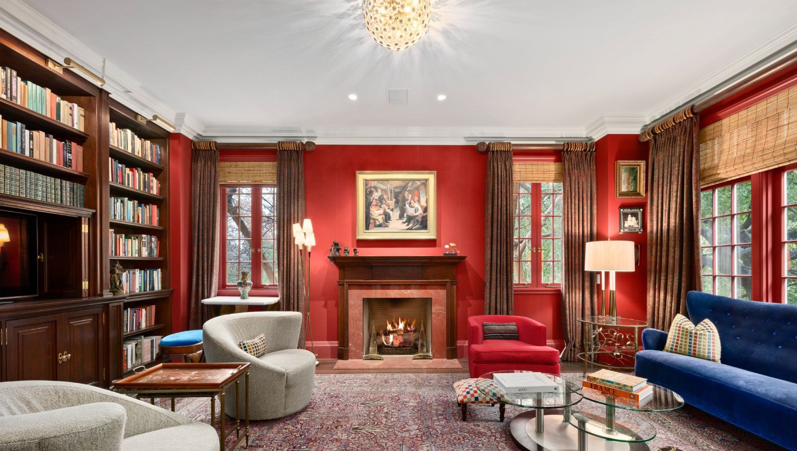 Mahogany paneled library with marble fireplace and red walls