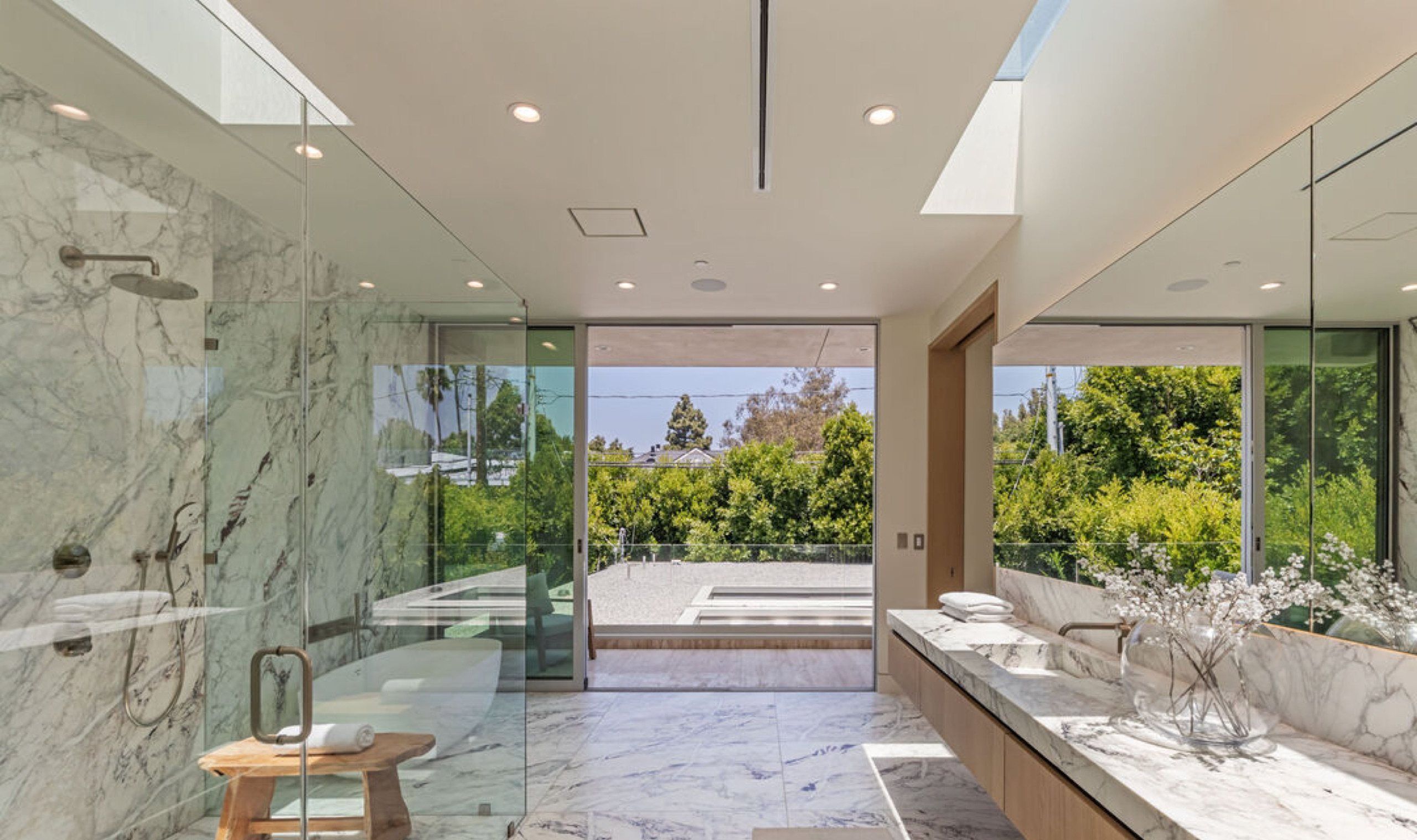 Primary bath opening to a terrace with garden views