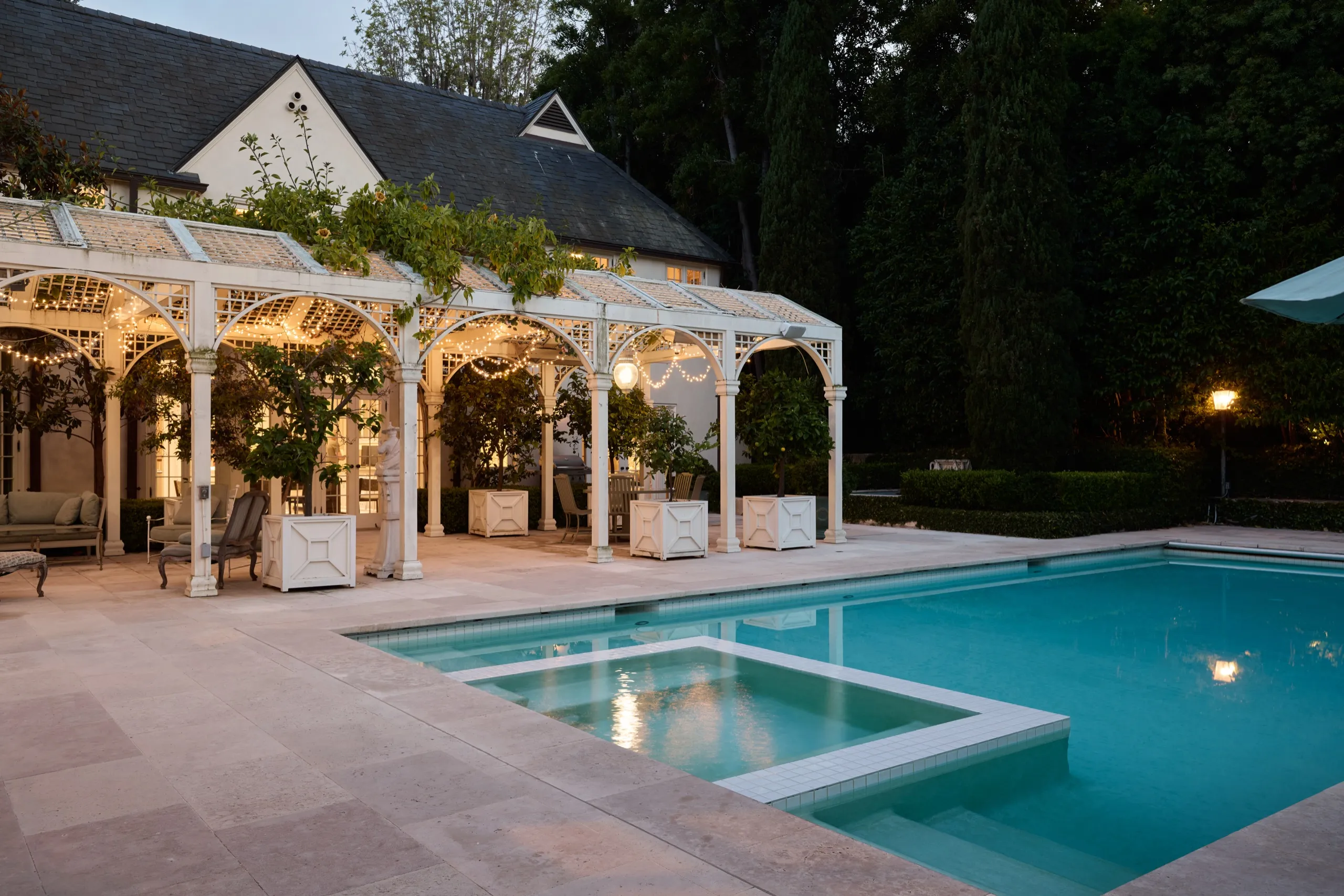 Saltwater pool and illuminated pergola at dusk, 10301 Strathmore Drive