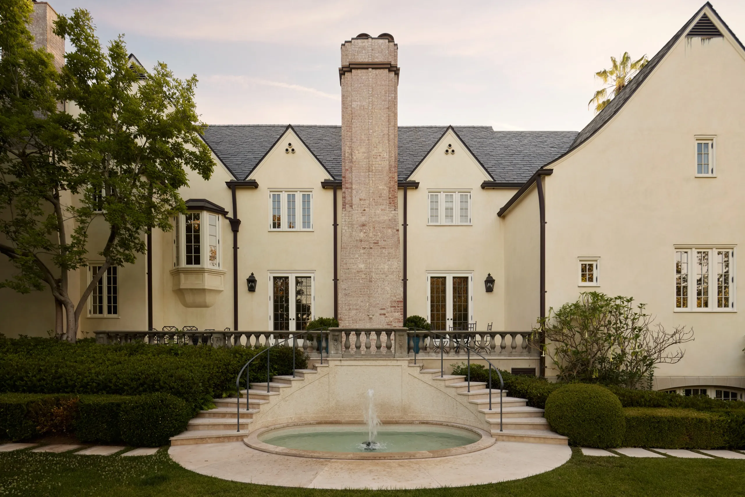 Rear facade with brick chimney and fountain at 10301 Strathmore Drive