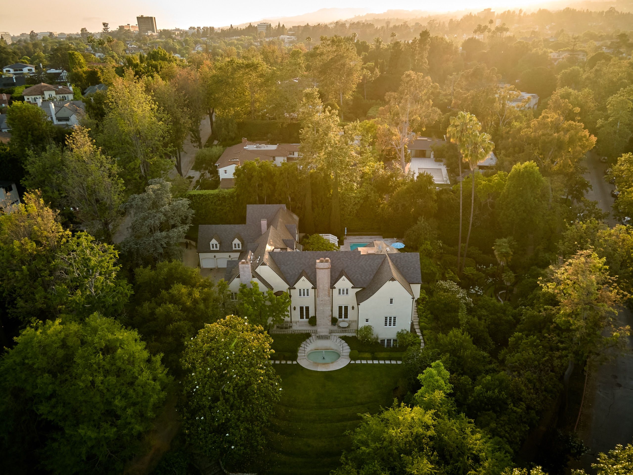 Aerial view of the Strathmore estate among mature trees in Little Holmby at sunset